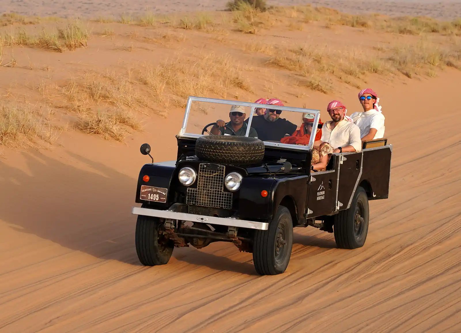 Family riding in an open top Land Rover LS2 in the Dubai Desert