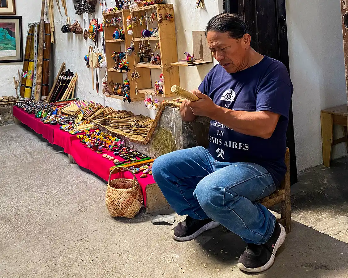 Jose Luis Pichamba crafts a traditional flute in his Otavalo music workshop