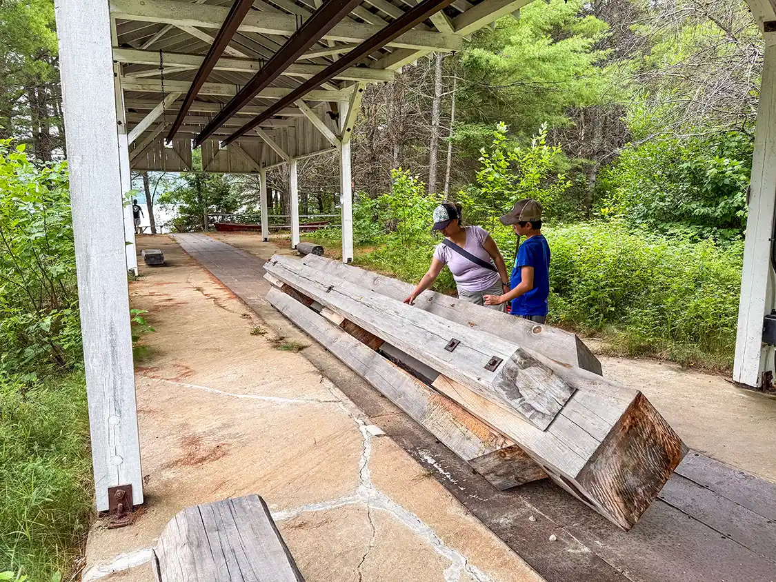 A mother and son look at historic logging equipment at Opemican National Park