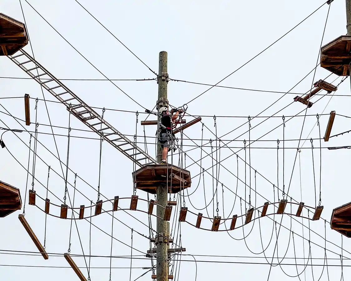 A man climbs along a Treetop Walk at TyroParc in Saint Agathe des Monts in Quebec