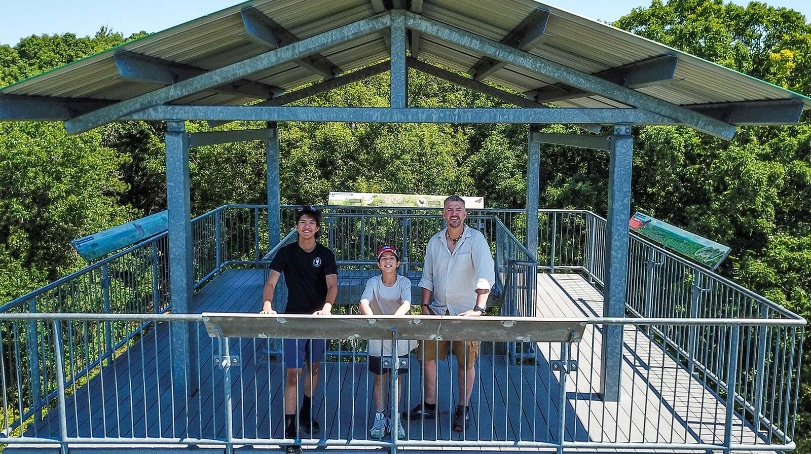 A father and his two sons stand atop an observation tower in Sager Conservation Area while exploring the Bay of Quinte