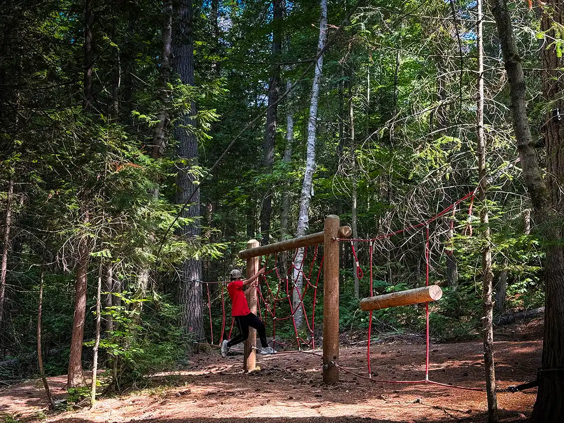 A boy plays on a wilderness playground in Parc National d'Opemican