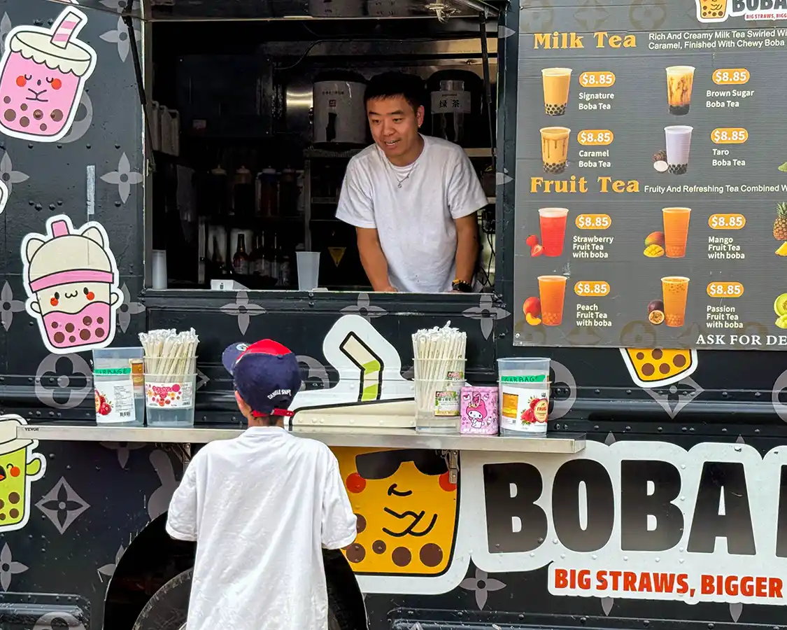 A boy orders boba tea at the West Zwicks Island pop-up village