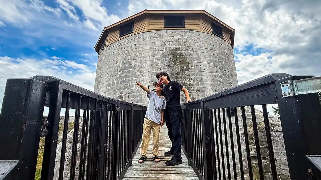 Two boys stand on a walkway at Murney Tower while they experience a family weekend in Kingston, Ontario