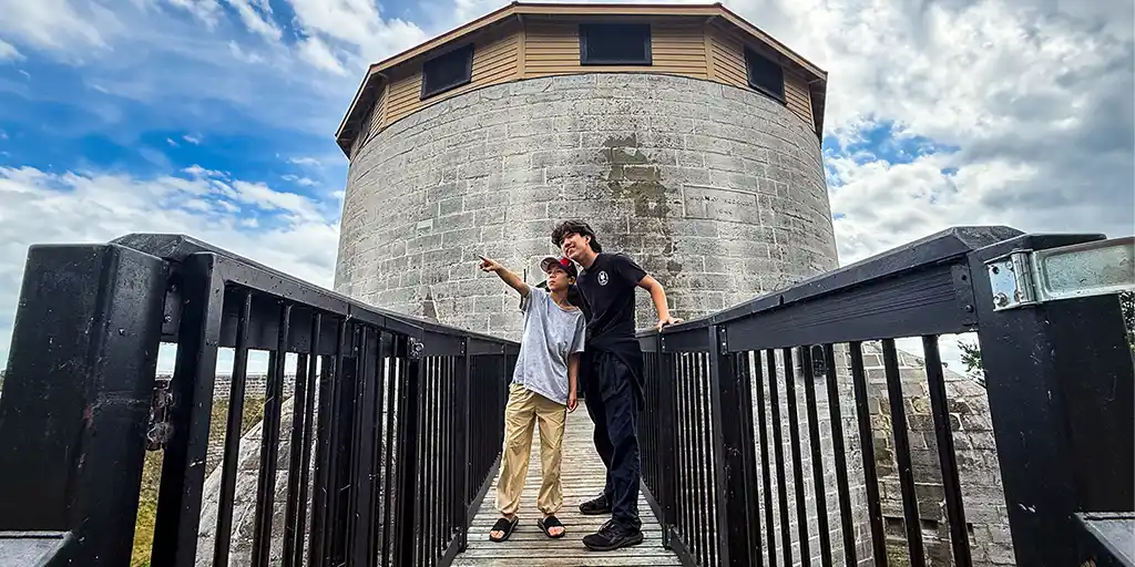 Two boys stand on a walkway at Murney Tower while they experience a family weekend in Kingston, Ontario