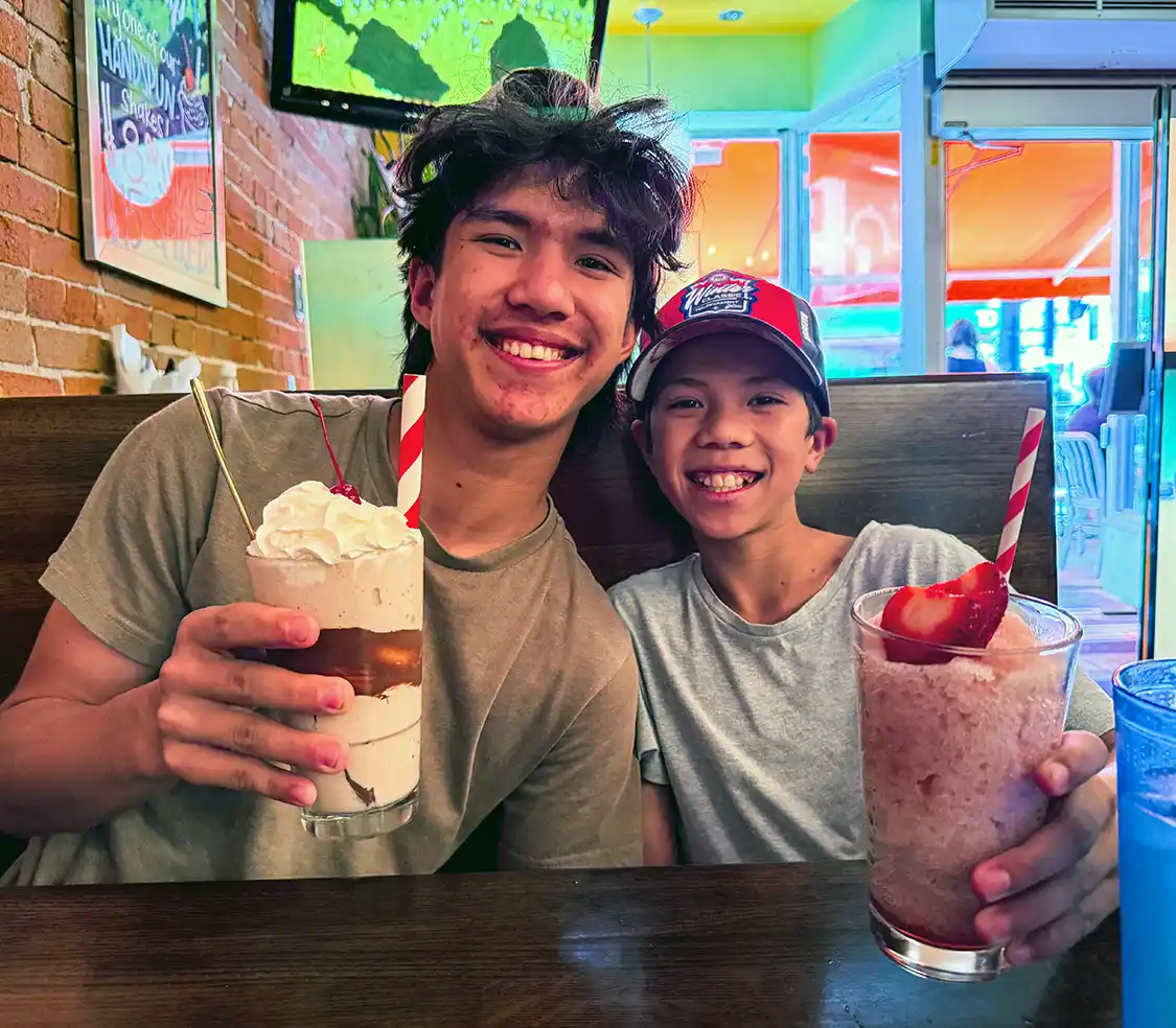 Two boys cheers milkshakes at Harper's Burger Shack in Kingston, Ontario