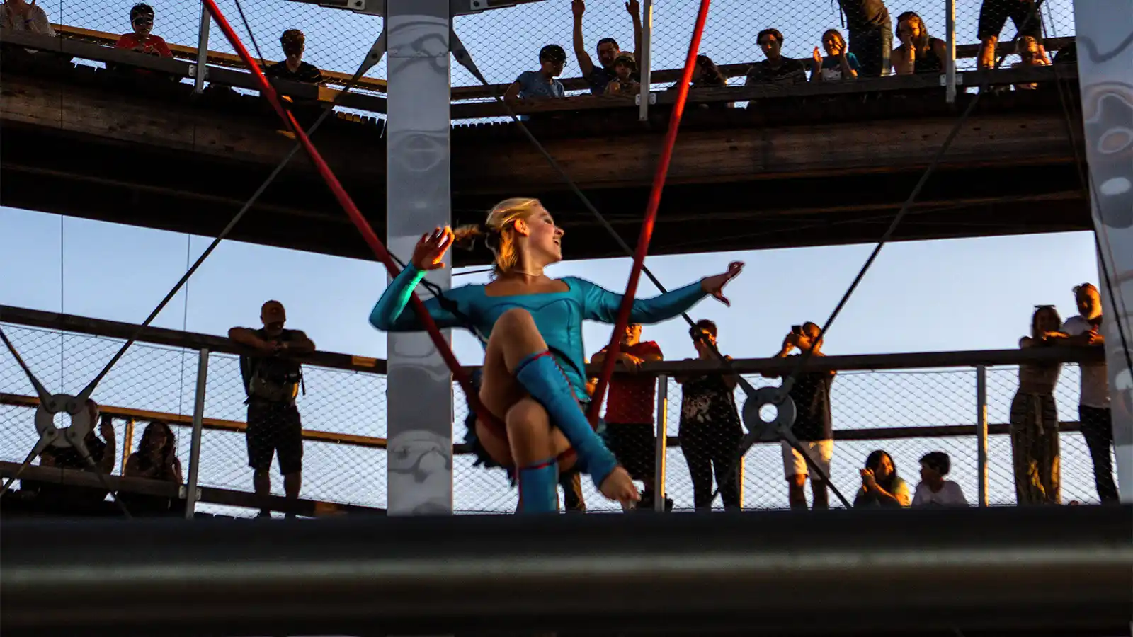 A female acrobat performs on an aerial silk in an open-air observatory tower during summer in Mont Tremblant