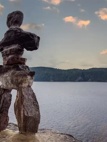 An inukshuk stands on a rock overlooking Lake Temiskaming in Parc National d'Opemican