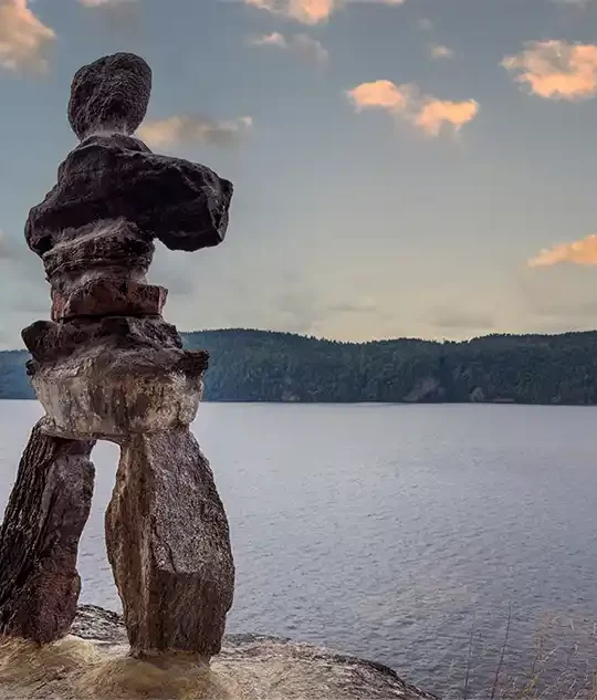 An inukshuk stands on a rock overlooking Lake Temiskaming in Parc National d'Opemican