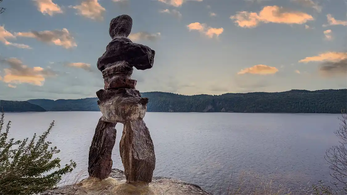 An inukshuk stands on a rock overlooking Lake Temiskaming in Parc National d'Opemican