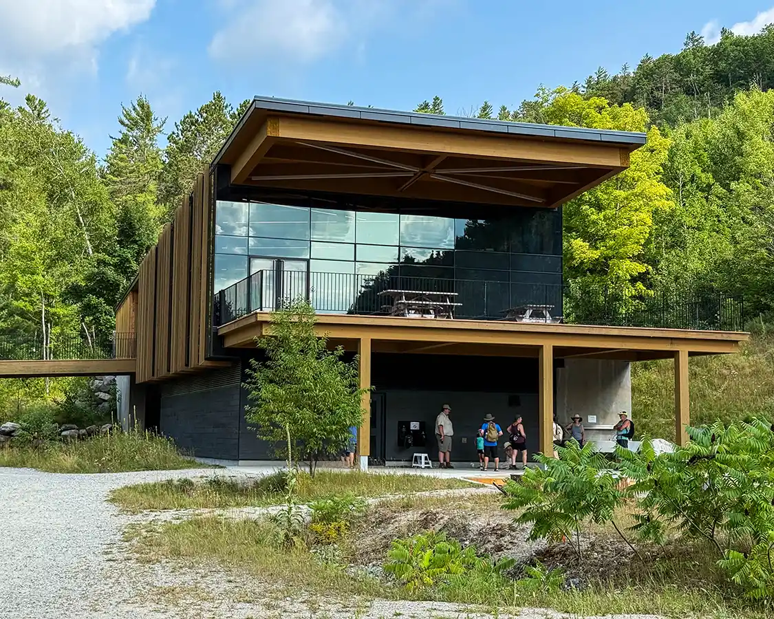 A modern wooden building with large glass windows in the forest
