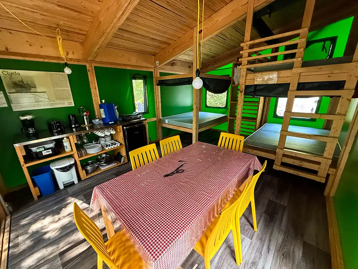 Beds, a table, and a kitchen within a Sepaq Ready-to-Camp tent in Quebec