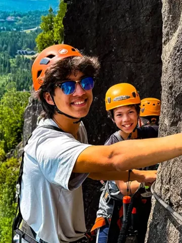 What is Via Ferrata? Two boys climb across the face of a cliff in Quebec