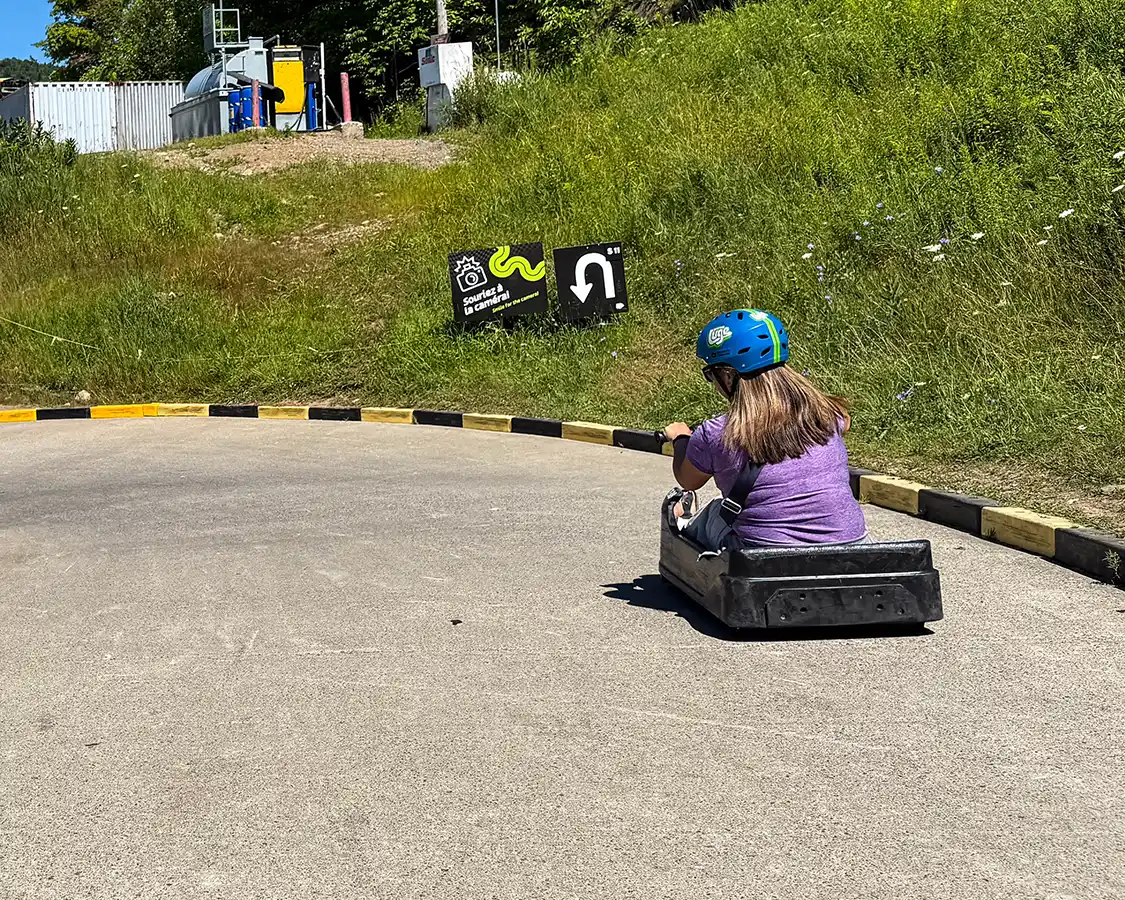 A woman rides the Mountain Luge down Mont-Tremblant in the summer