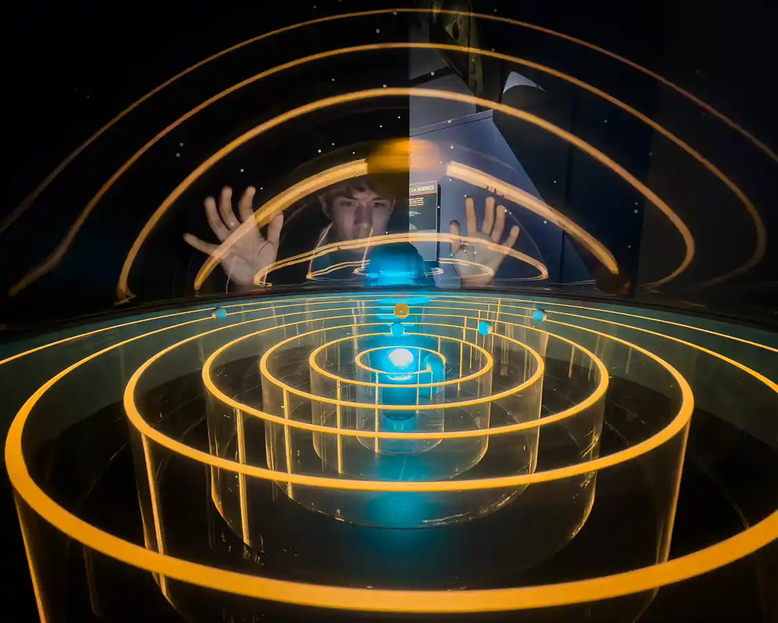 A boy looks through a model of the solar system at the Mont-Megantic ASTROLab
