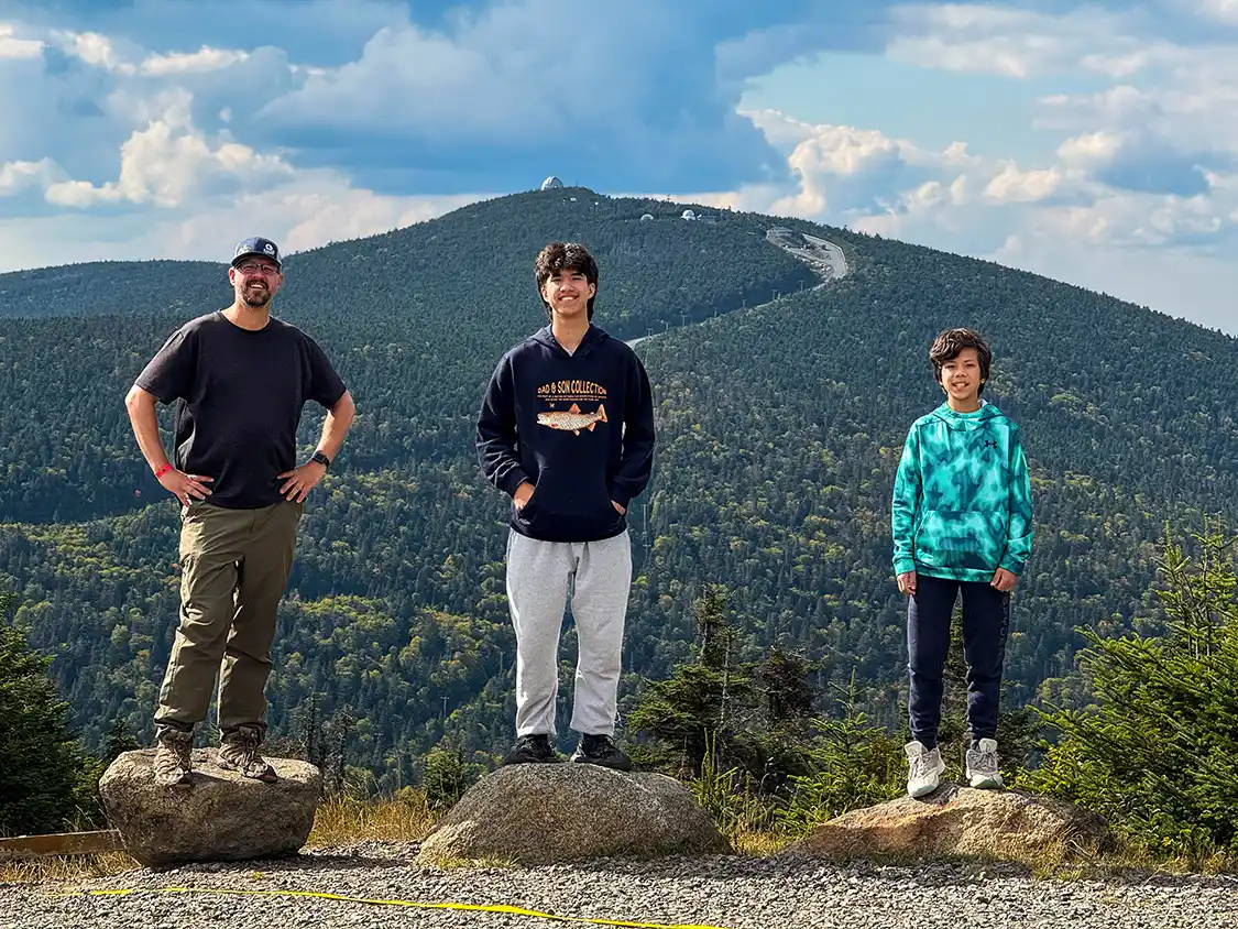A father and his two sons hike on Mount St. Joseph in Mont-Megantic National Park