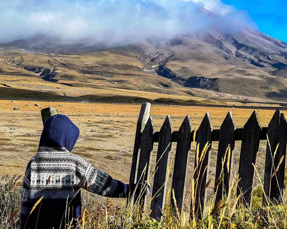 A young boy walks alongside a broken fence in Cotopaxi National Park