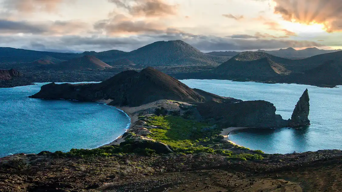 One of the Galapagos Islands splits the Pacific Ocean at sunset