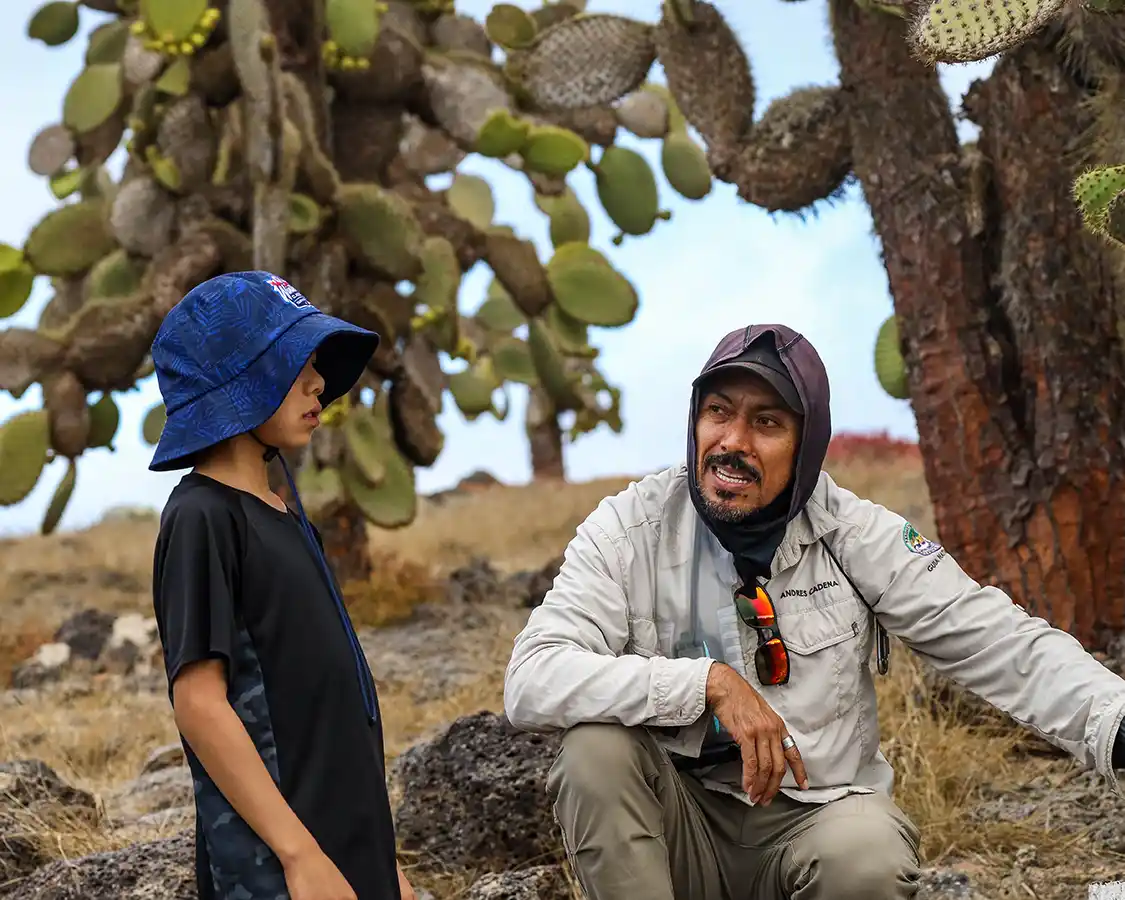 A Galapagos Islands guide points out wildlife to a young boy