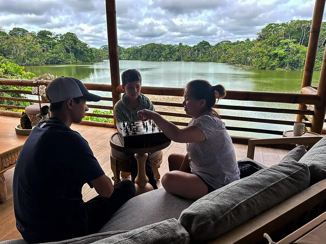 A family plays a board game at an observation lounge in La Selva Eco Lodge
