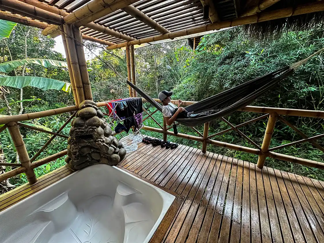 A teenager relaxes in a hammock on the deck of his Amazon lodge