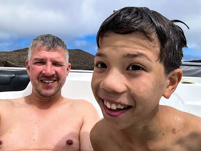 A young boy in a hot tub on a cruise takes a selfie with his travel camera gift