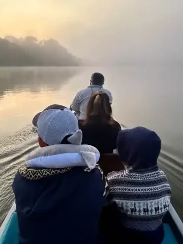 A family rides a canoe at dawn through the Amazon Rainforest to La Selva Eco Lodge in Ecuador