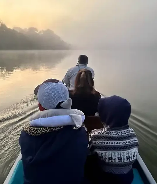 A family rides a canoe at dawn through the Amazon Rainforest to La Selva Eco Lodge in Ecuador