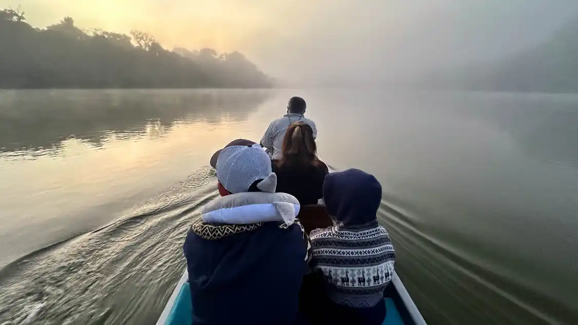 A family rides a canoe at dawn through the Amazon Rainforest to La Selva Eco Lodge in Ecuador