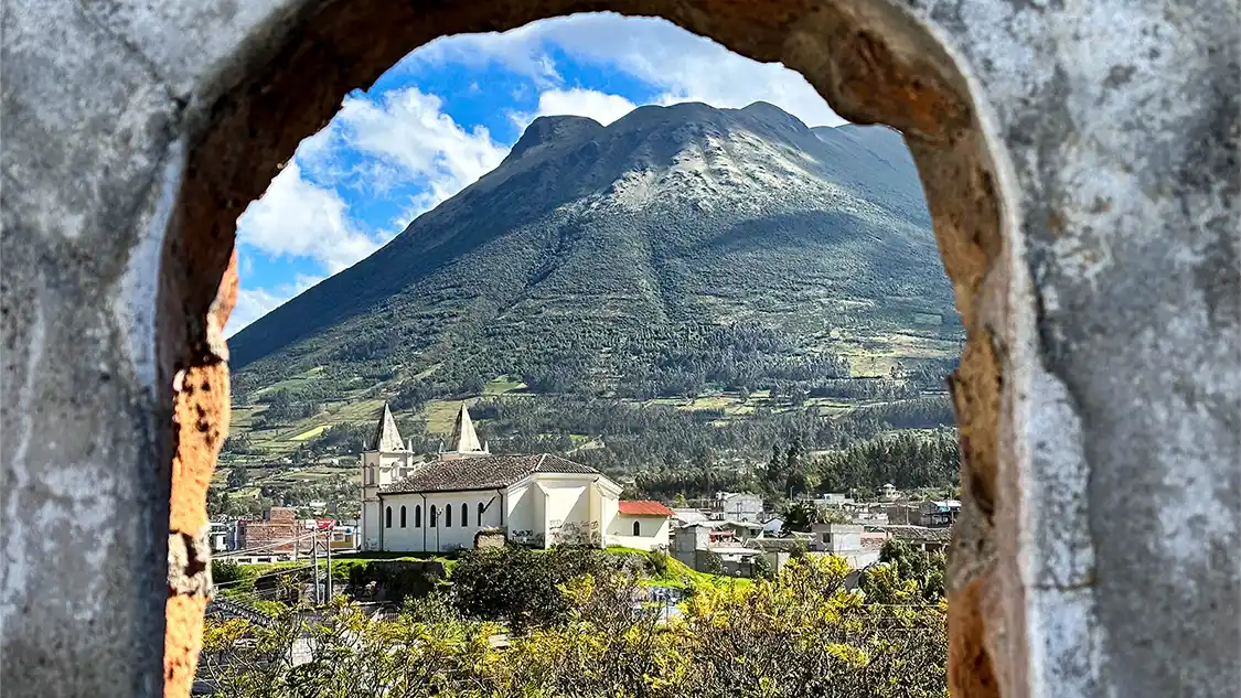 A view of accommodations in Otavalo, Ecuador from a stone archway