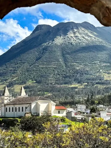 A view of accommodations in Otavalo, Ecuador from a stone archway