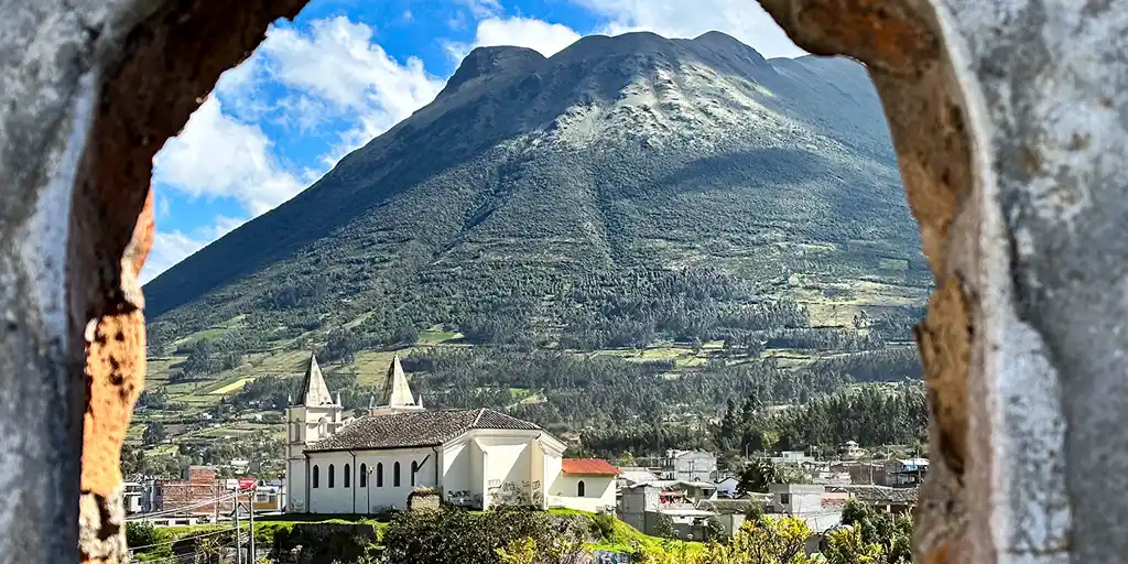 A view of accommodations in Otavalo, Ecuador from a stone archway