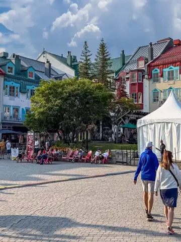 Families walk among the colorful buildings of the accommodations at Mont-Tremblant, Quebec