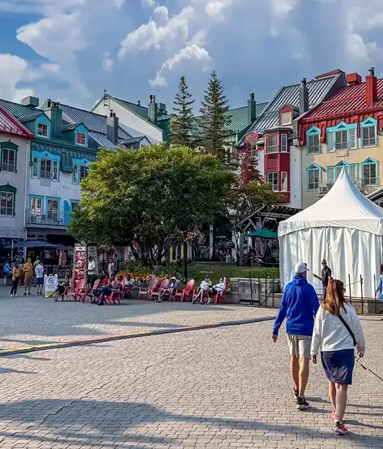 Families walk among the colorful buildings of the accommodations at Mont-Tremblant, Quebec