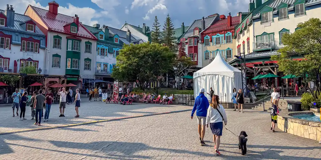 Families walk among the colorful buildings of the accommodations at Mont-Tremblant, Quebec