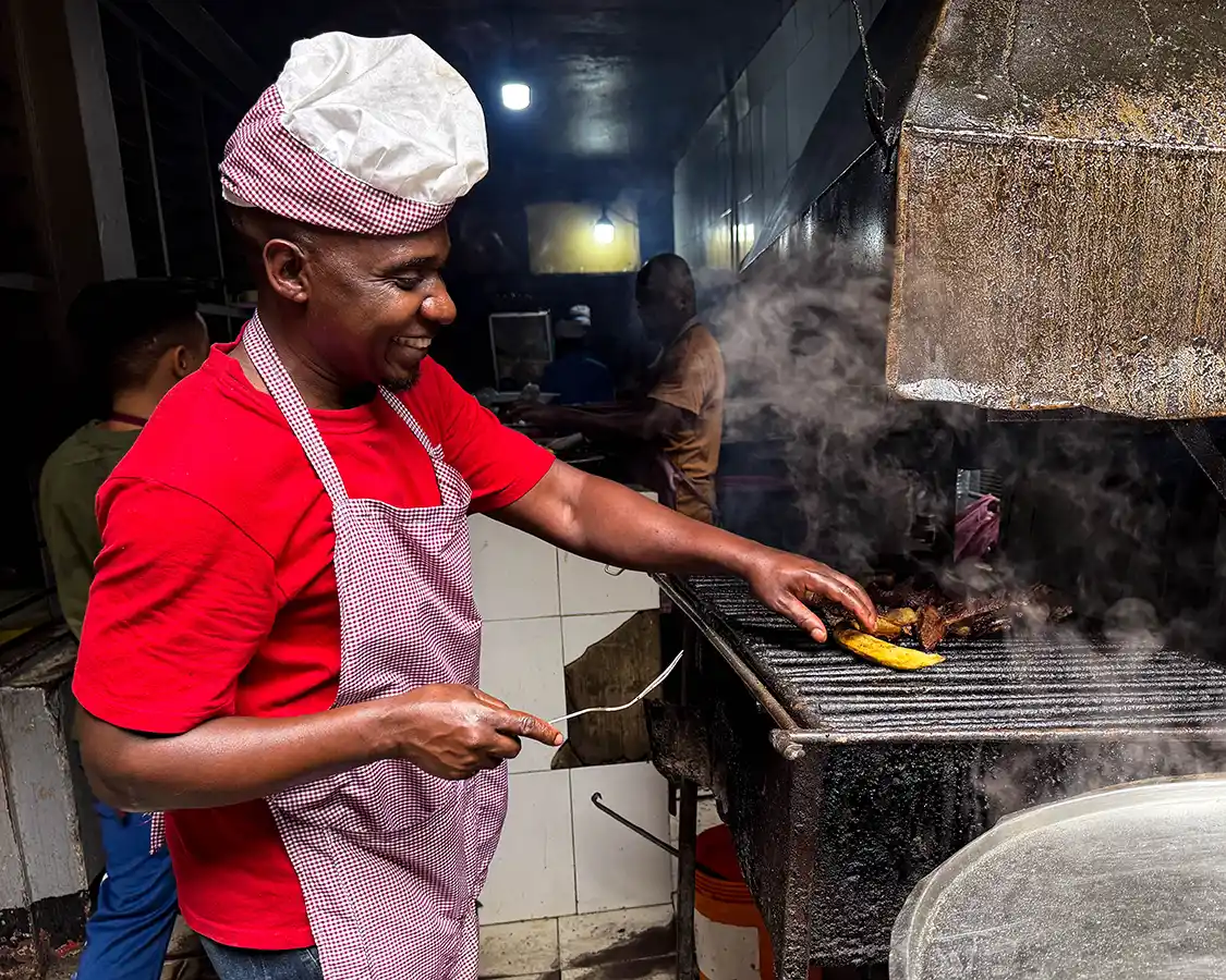 A cook grills up traditional food at the Arusha Market
