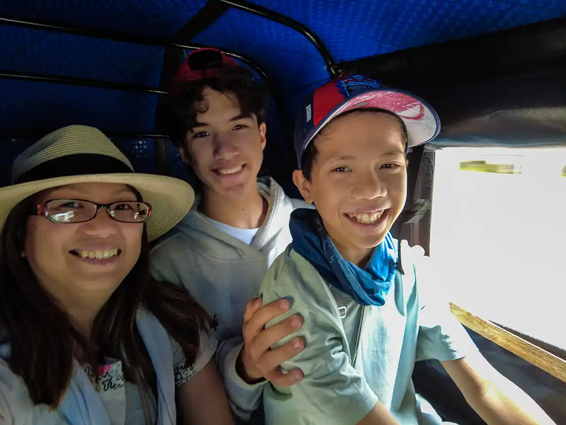A mother and her children ride a tuk tuk in Arusha Tanzania