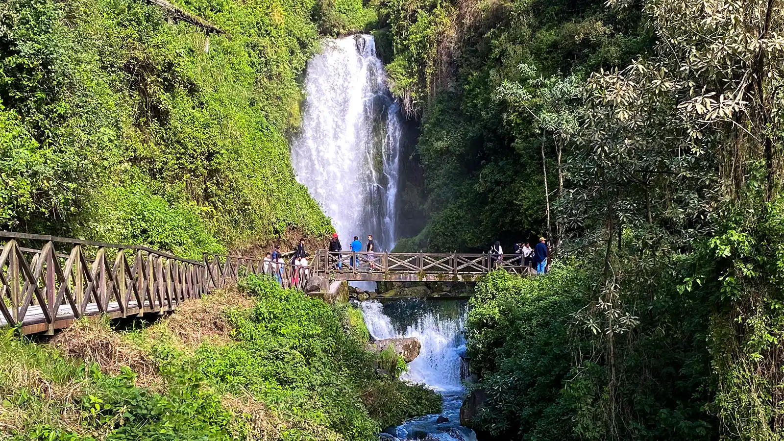 A beautiful waterfall cascades into a lush green canyon in Otavalo, Ecuador