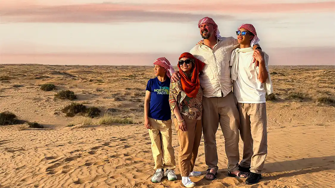 A family smiling on a desert tour happy because they're connected with the best eSIM for travel