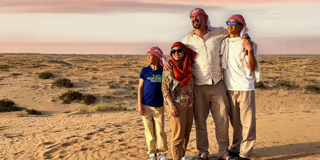 A family smiling on a desert tour happy because they're connected with the best eSIM for travel