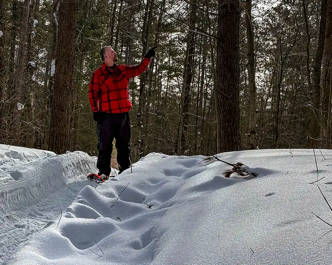 A man Snowshoeing through deep snow in Rouge National Urban Park in Toronto