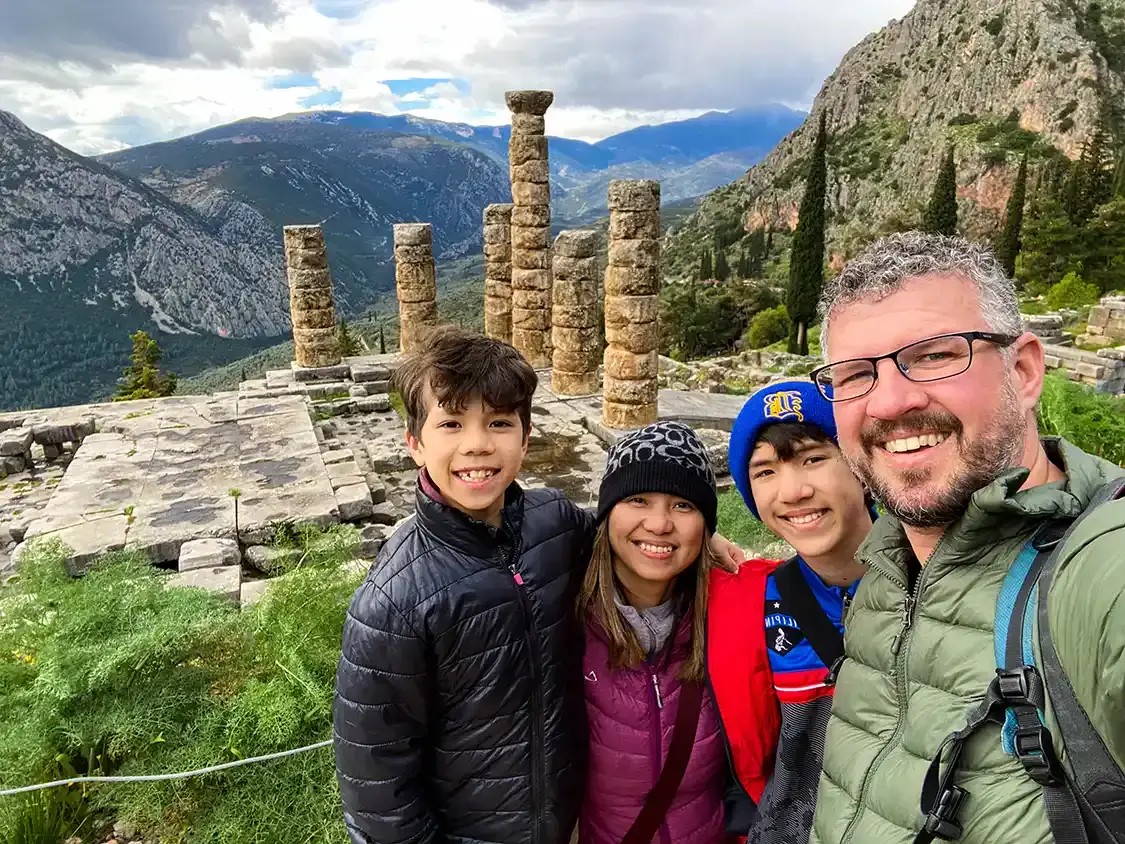 A family wears toques and jackets while exploring the ruins of Delphi in winter
