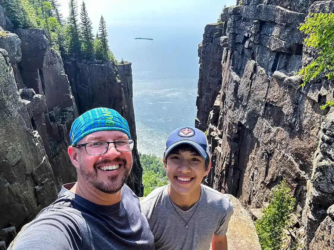 A father and son pose for a photo while hiking in Thunder Bay Canada