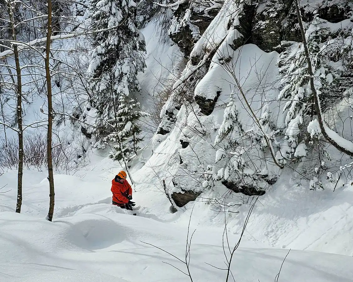 A man wearing an ice climbing helmet snowshoeing throw waist-deep snow in Thunder Bay