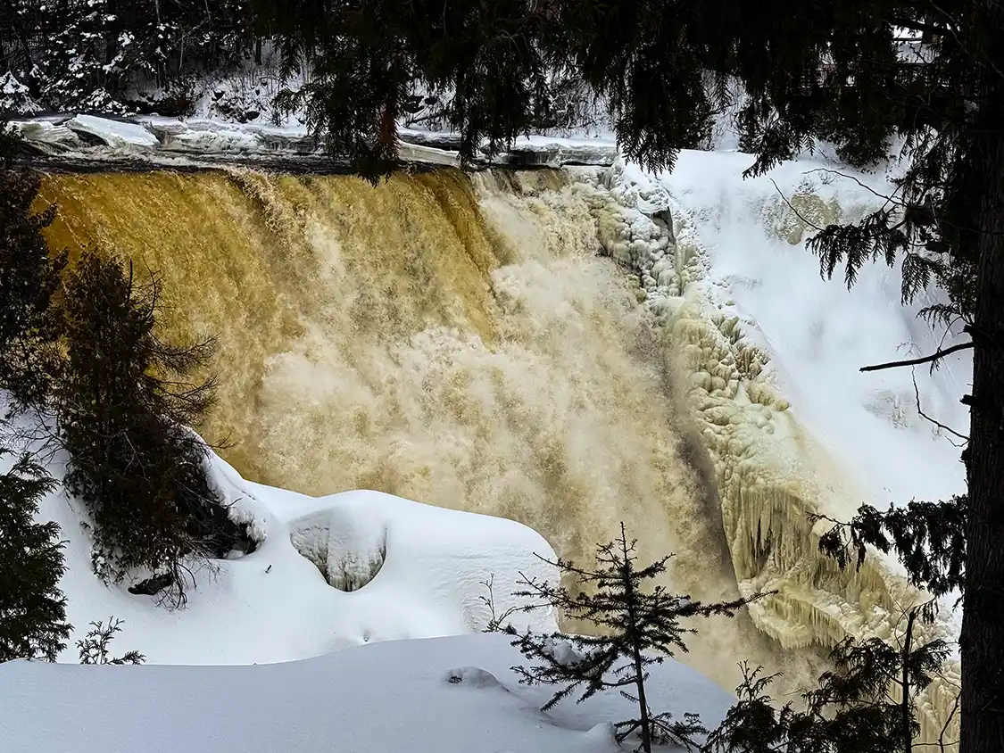 The roaring waters of Kakabeka Falls tumble through ice covered rocks