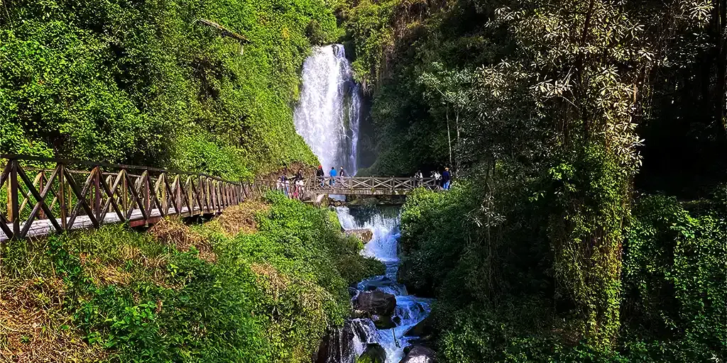 Beautiful waterfall cascading under a bridge in Otavalo, Ecuador