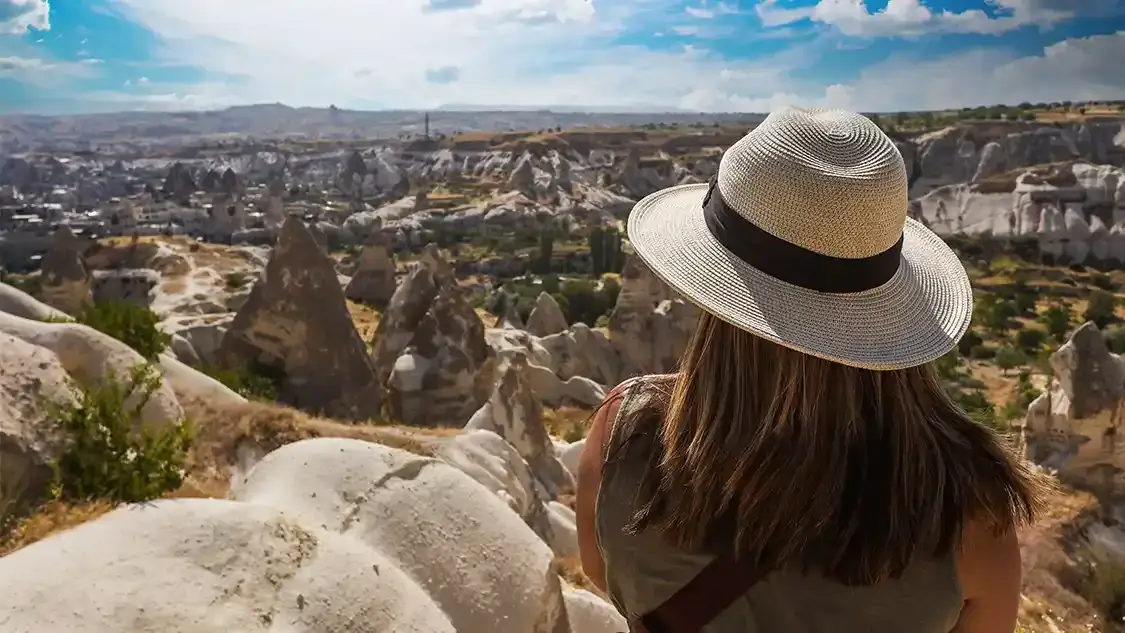 Woman looks out over the Cappadocia landscape while planning a family travel packing list for Turkey