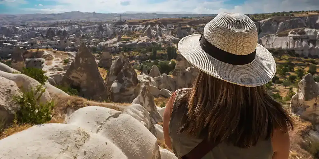 Woman looks out over the Cappadocia landscape while planning a family travel packing list for Turkey