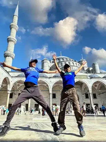 Two boys jump for joy in front of the Blue Mosque in Istanbul Turkey Family Travel Tips