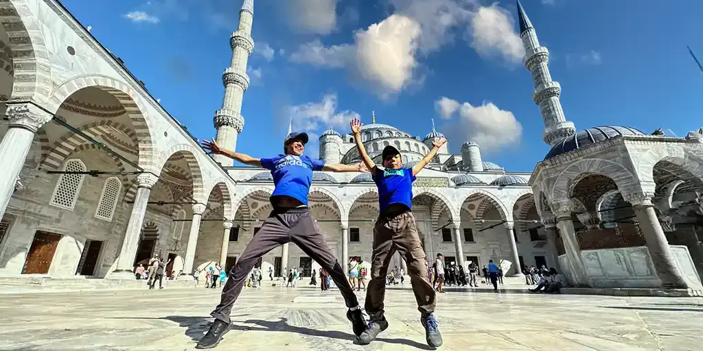 Two boys jump for joy in front of the Blue Mosque in Istanbul Turkey Family Travel Tips
